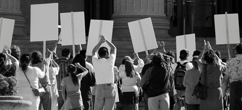 Crowd protesting with signs. 