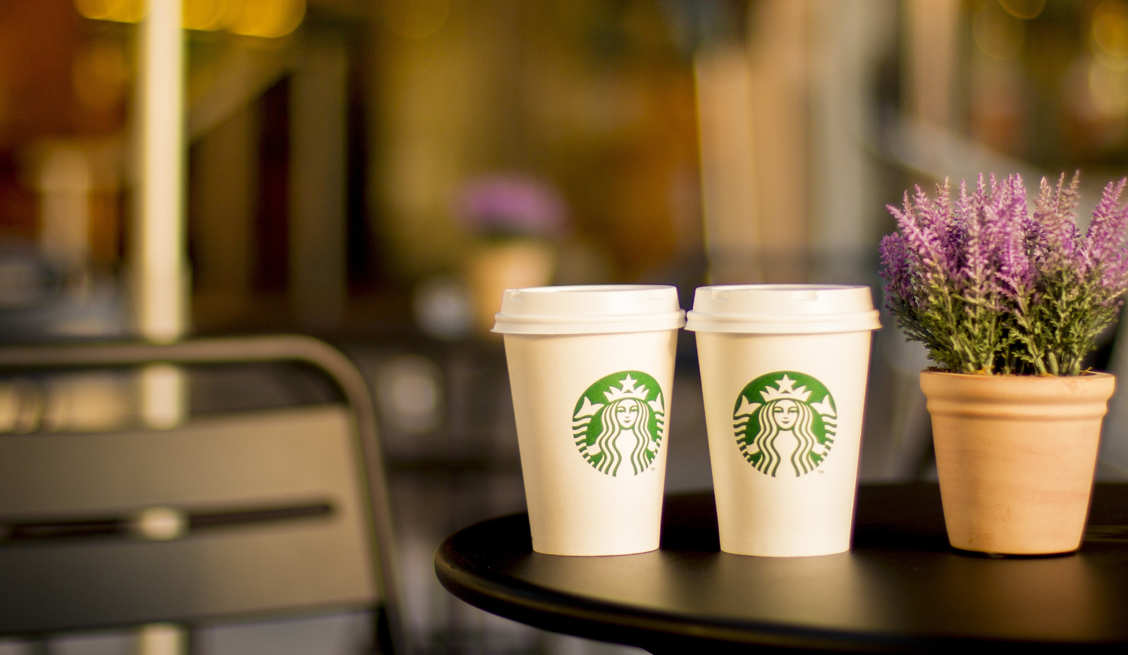 Two Starbucks cups on a table.