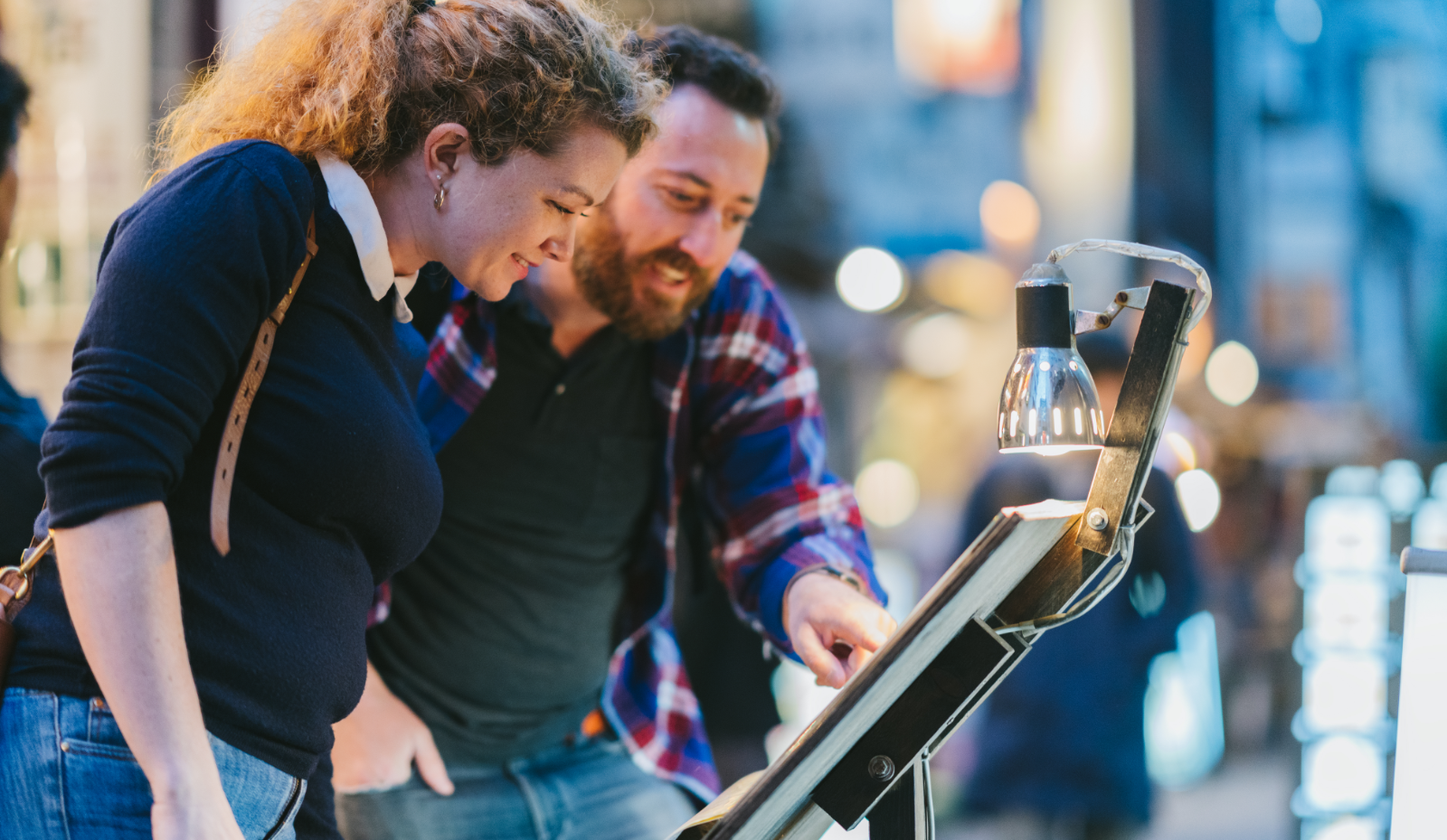 Couple checking food menu outside restaurant. 