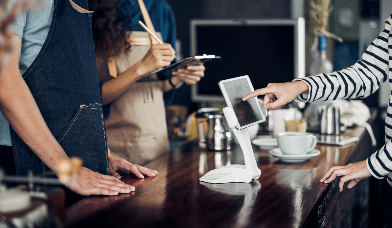 Customer self-ordering from a kiosk at a coffee shop. 